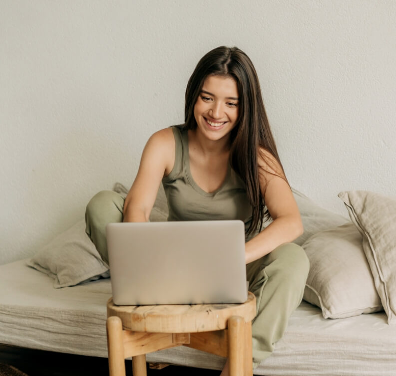 mycala-young-happy-woman-is-working-at-home-on-a-laptop